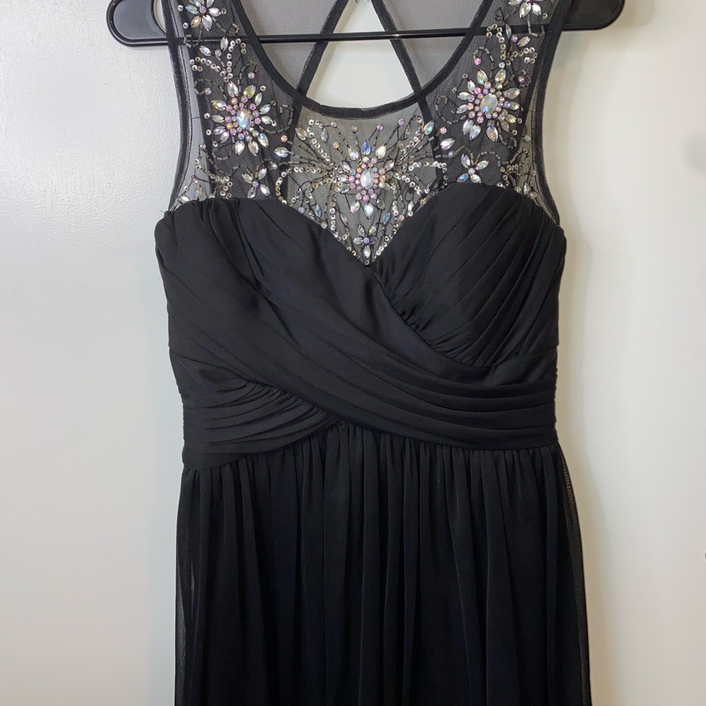 Black knee length dress with silver/white jewels around the collar bone area.